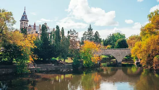 A bridge crossing the river, leading to a building.